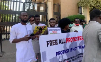 Nigerianische Sozialist*innen protestieren mit einem Banner "Free all Protesters" gegen den Hochverrats-Prozess in Abuja